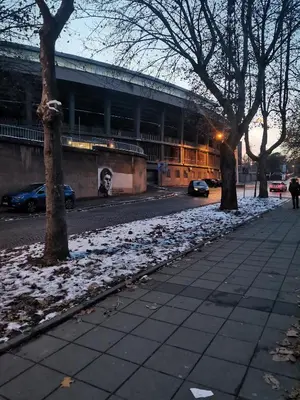 a snow covered sidewalk in front of a building at Stadion apartman in Belgrade