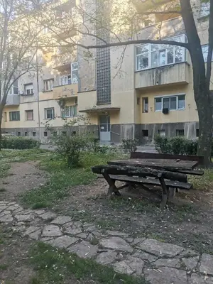 a wooden bench sitting in front of a building at Stadion apartman in Belgrade