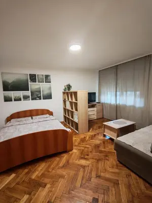 a bedroom with wooden floors and a bed and a television at Kraljevica Marka Apartman in Belgrade