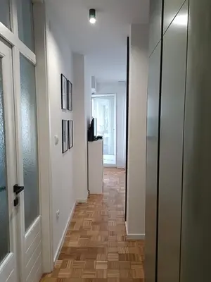 a hallway with white walls and a wooden floor at Green Place in Vračar (historical)