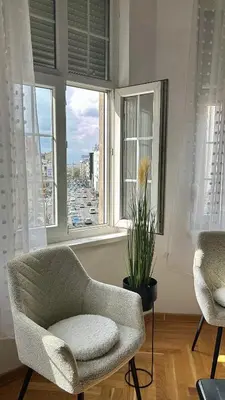 a living room with a chair and a window at Urban Aura Belgrade in Belgrade