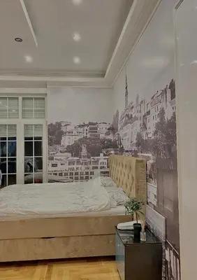 a bedroom with a large bed with a painting on the wall at Urban Aura Belgrade in Belgrade