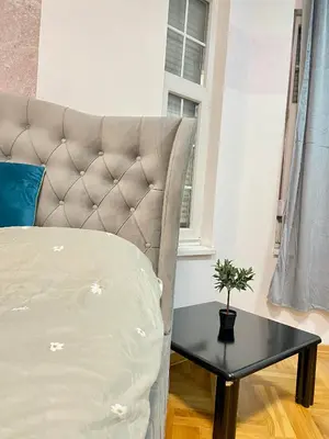 a bedroom with a bed and a table with a plant at Urban Aura Belgrade in Belgrade