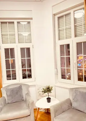 a living room with two couches and two windows at Urban Aura Belgrade in Belgrade