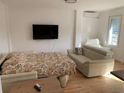 a bedroom with a bed and a couch and a television at Premium stan Novi Beograd in Novi Beograd