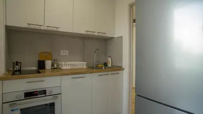 a kitchen with white cabinets and a sink at Premium stan Novi Beograd in Novi Beograd