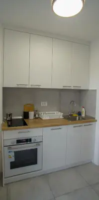 a kitchen with white cabinets and a sink at Premium stan Novi Beograd in Novi Beograd