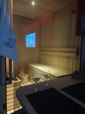 two wine glasses sitting on a table in a sauna at Lux studio sa saunom Ampelitsi in Ledine