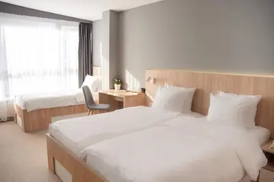 a hotel room with two beds and a chair at Olivia Rooms in Belgrade