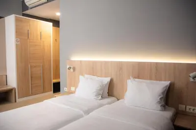 a bedroom with two beds with white pillows at Olivia Rooms in Belgrade