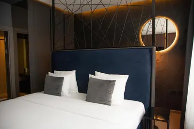 a bedroom with a white bed with a blue headboard at Olivia Rooms in Belgrade