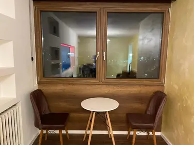 a table and two chairs in front of a window at Loronobeo.forest in Belgrade