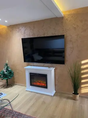 a living room with a fireplace with a tv on a wall at Kapetan-Misa in Belgrade