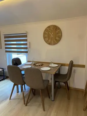 a dining room table with chairs and a clock on the wall at Kapetan-Misa in Belgrade
