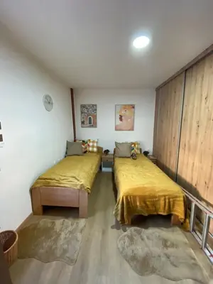 two beds in a room with yellow sheets on them at Kapetan-Misa in Belgrade