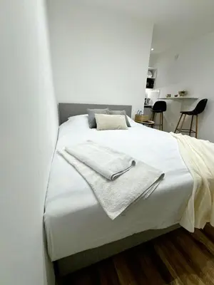 a white bed with a towel on top of it at Global City Studio in Belgrade