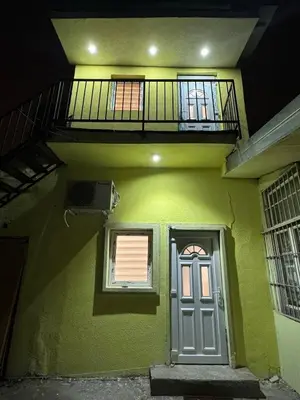 a green house with a door and a balcony at Global City Studio in Belgrade