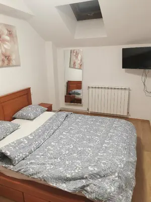 a bedroom with a bed with a gray comforter at Apartman Milica in Belgrade