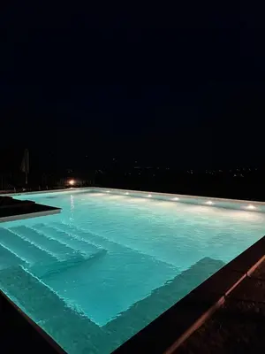 a swimming pool lit up at night at Ozoni & Spa in Sopot