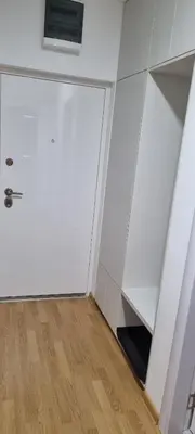 a room with a white door and a wooden floor at Finans1 in Ruma