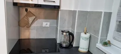 a kitchen counter with a coffee maker on a counter top at Finans1 in Ruma