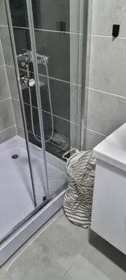 a shower with a glass door in a bathroom at Finans1 in Ruma