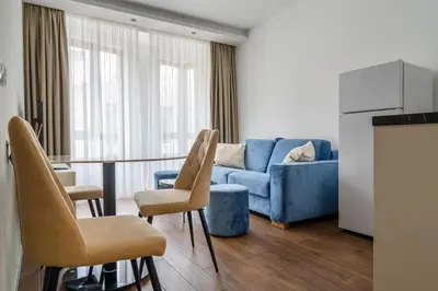 a living room with a blue couch and a table and chairs at Kondina Suites in Belgrade