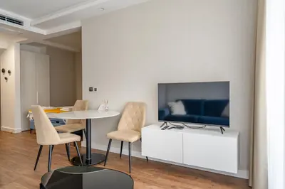 a living room with a table and a tv at Kondina Suites in Belgrade