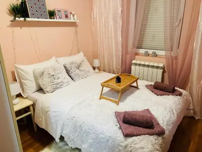 a small bedroom with a bed with a table on it at Aero Fly apartment Belgrade in Belgrade