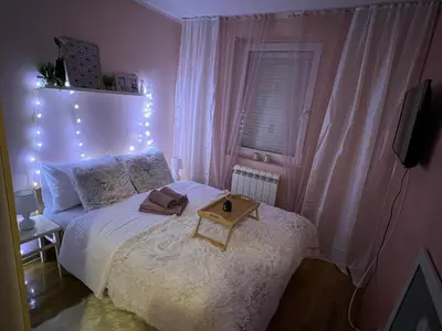a bedroom with a bed with a table on it at Aero Fly apartment Belgrade in Belgrade