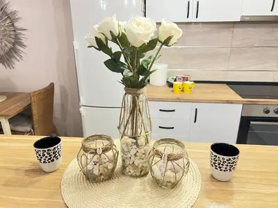 a vase with white roses sitting on top of a table at Aero Fly apartment Belgrade in Belgrade