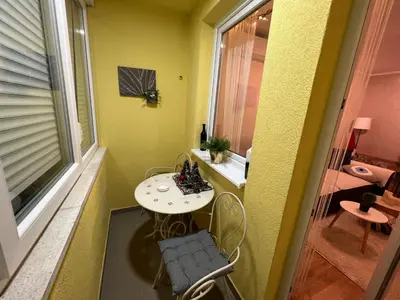 a small table and chairs in a room with a window at Aero Fly apartment Belgrade in Belgrade