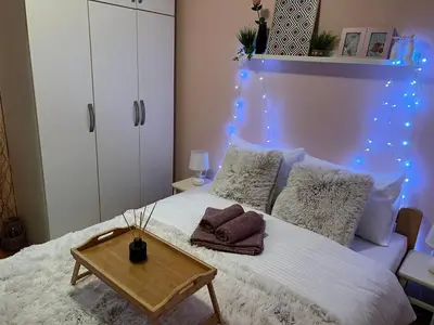 a bedroom with a white bed with blue lights at Aero Fly apartment Belgrade in Belgrade
