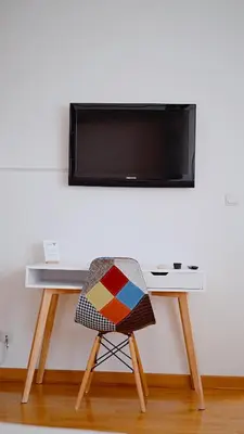 a chair sitting in front of a desk with a television at Apartment SOFI Belville in Novi Beograd