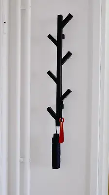 a black tree with a red bell on a wall at Apartment SOFI Belville in Novi Beograd