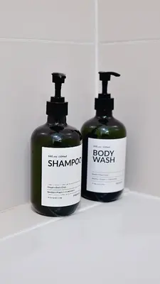 two bottles of shampoo and soap sitting on a shelf at Apartment SOFI Belville in Novi Beograd