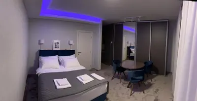 a bedroom with a bed and a table with chairs at Oaza Mirijevo in Mirijevo