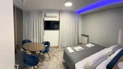 a hotel room with a bed and a table and chairs at Oaza Mirijevo in Mirijevo
