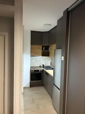 a kitchen with black cabinets and a stainless steel refrigerator at Oaza Mirijevo in Mirijevo