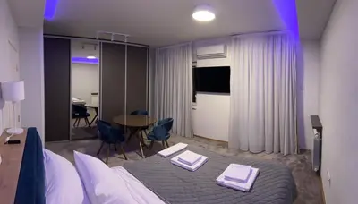 a hotel room with a bed and a table and chairs at Oaza Mirijevo in Mirijevo