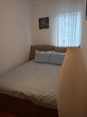 a bedroom with a bed with a couch and a window at Clockwork orange apartment in Vračar (historical)