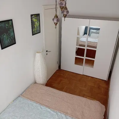 a room with a white vase and a bedroom at Clockwork orange apartment in Vračar (historical)