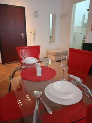 a table with two plates and wine glasses on it at Clockwork orange apartment in Vračar (historical)