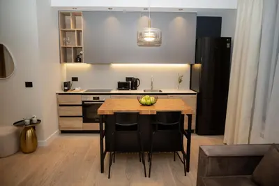 a kitchen with a table and chairs and a kitchen with a sink at Belgrade Simfonia - One bedroom apartment in Belgrade