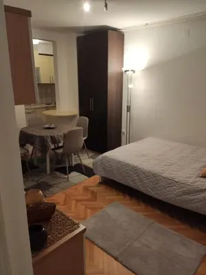 a bedroom with a bed and a table and a dining room at Panorama 40 in Sajmište