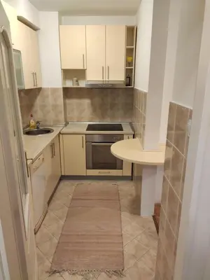 a small kitchen with white cabinets and a table at Panorama 40 in Sajmište