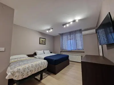 a bedroom with a bed and a flat screen tv at Center Prestige Apartments in Belgrade
