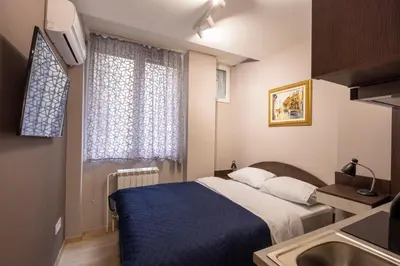 a bedroom with a blue bed and a window at Center Prestige Apartments in Belgrade