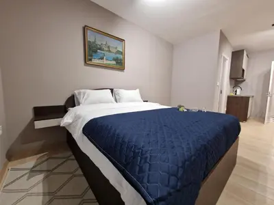 a bedroom with a large bed with a blue comforter at Center Prestige Apartments in Belgrade