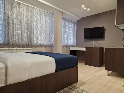 a bedroom with a bed and a flat screen tv at Center Prestige Apartments in Belgrade